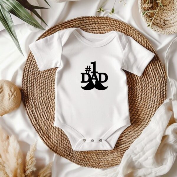 Een witte babyromper met een leuke en opvallende tekst op de voorkant 1 dad